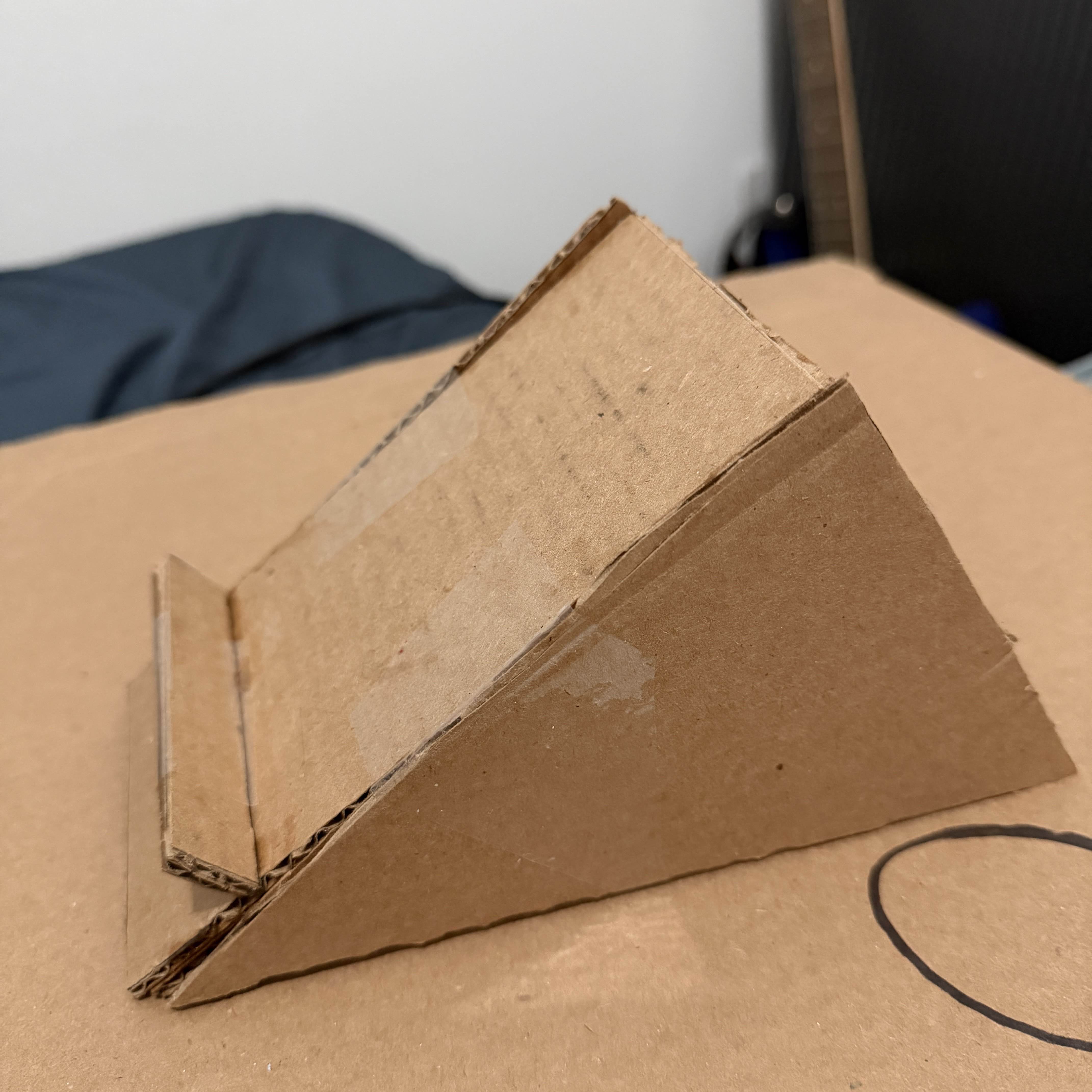 Side angle showing the second version of phone stand with refined design. I fixed the view-angle and reinforce it with tape.