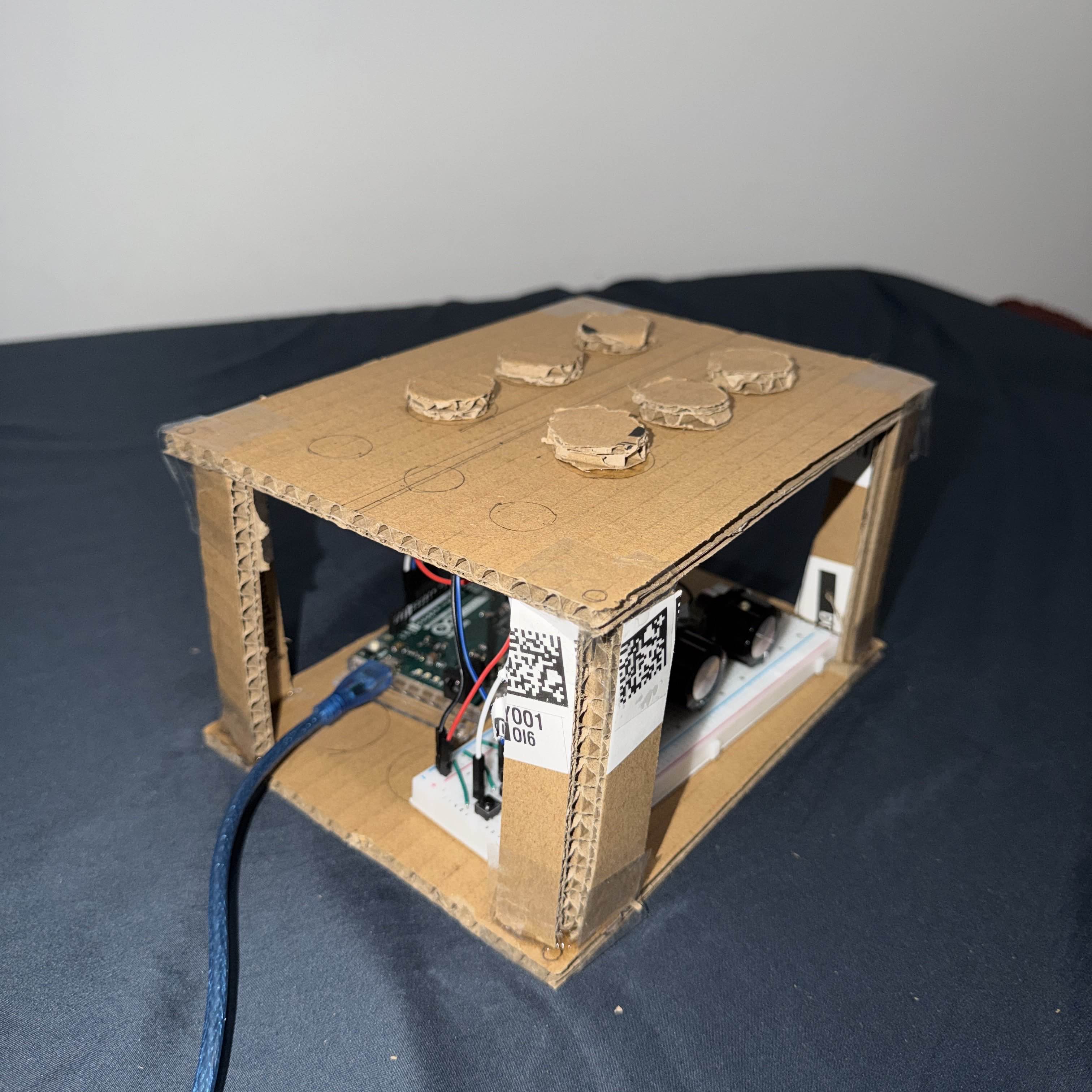 Assembled cardboard prototype demonstrating the final structure, including button layout, internal component space, and overall form factor.